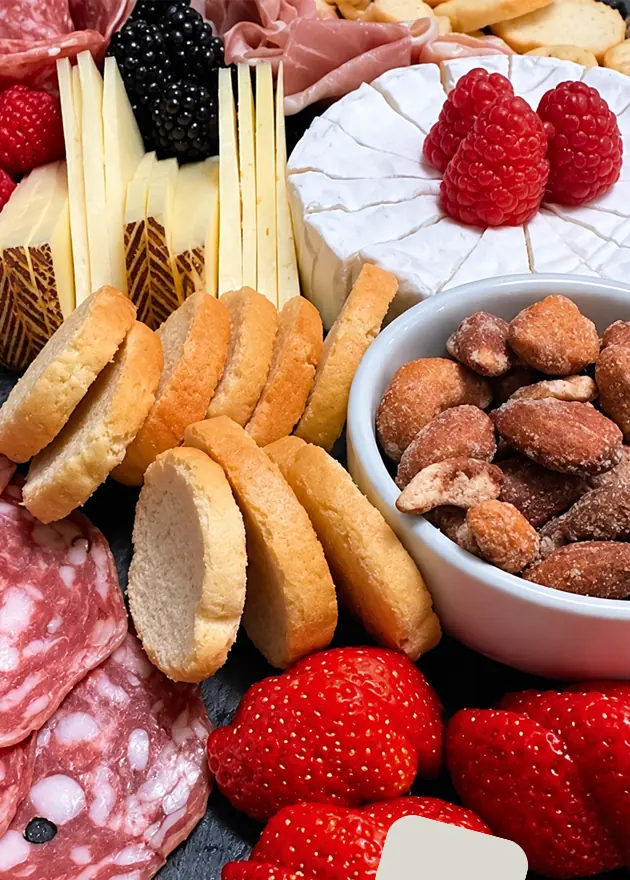 Tabla de quesos, carnes frías y frutos rojos para servicio ejecutivo